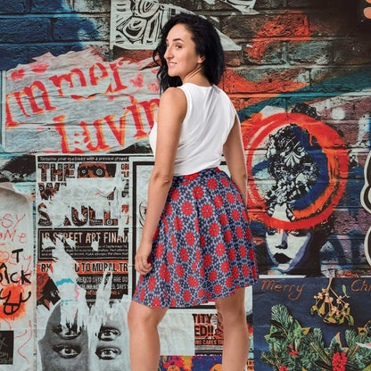 Woman in a red floral skater skirt and white top and standing in front of a colorful graffiti wall.
