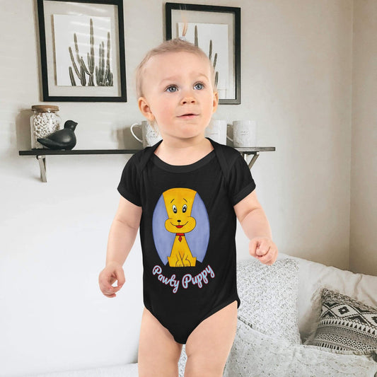 Baby wearing a black onesie with a puppy character and text, standing in a room.