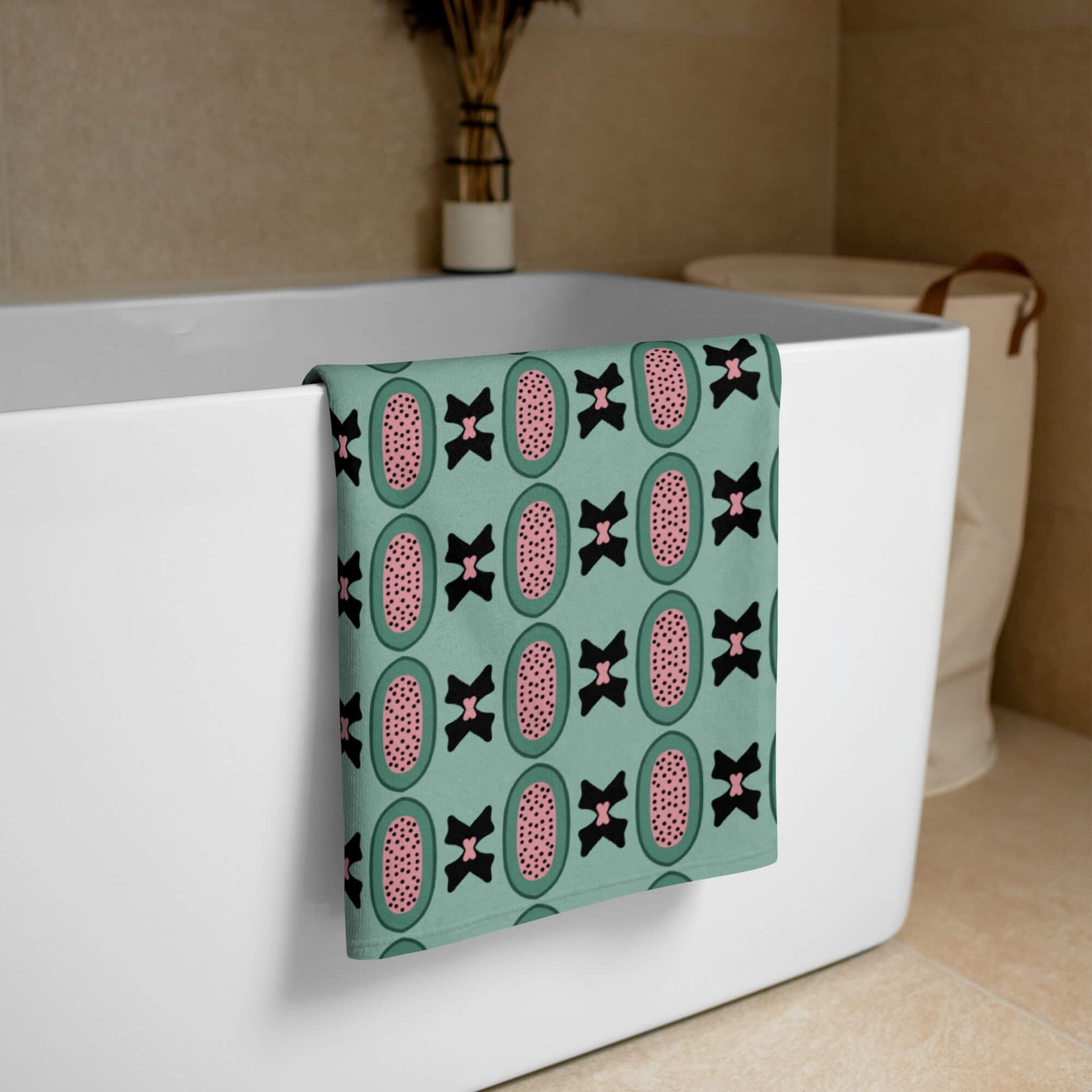 Pistachio green bath towel draped over a bathtub in a bathroom setting