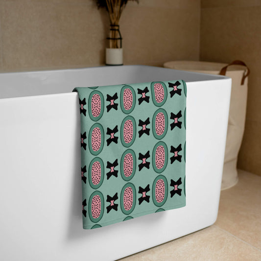 Pistachio green bath towel draped over a bathtub in a bathroom setting