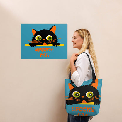 a woman posing beside a spooky cat poster with a matching tote bag