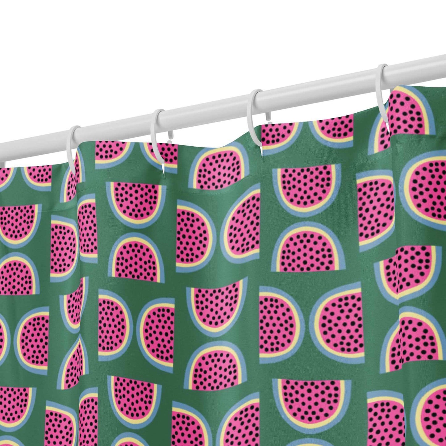 green shower curtain with pink watermelon pattern hanging from hooks close up