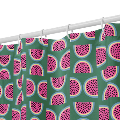 green shower curtain with pink watermelon pattern hanging from hooks close up