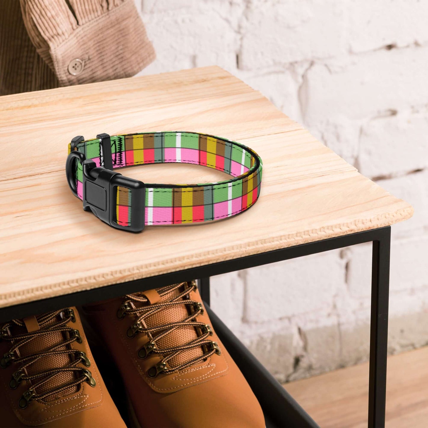 Colorful plaid dog collar on a wooden table with brown boots underneath.