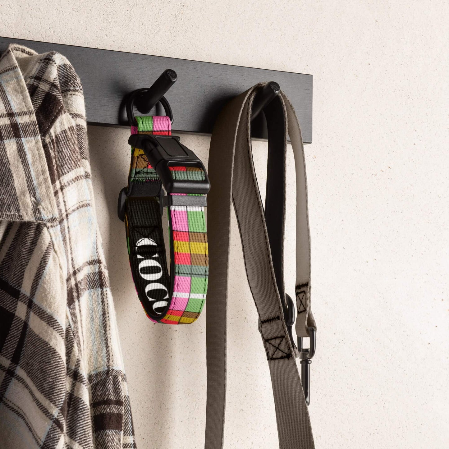 Plaid dog collars with name branding on a hook with a strap and plaid shirt.