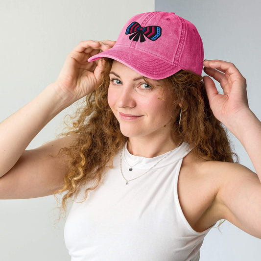 Woman wearing an one owl artist designed pink cotton twill cap with a colorful ribbon bow embroidery